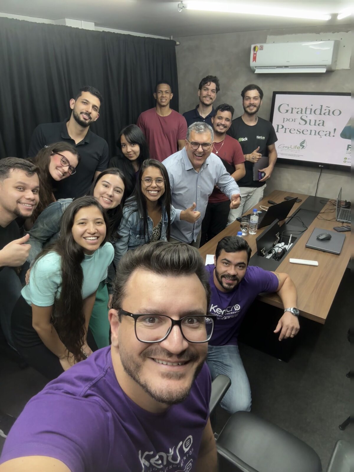Equipe da Kentro reunida em sala de encontro, sorrindo para selfie